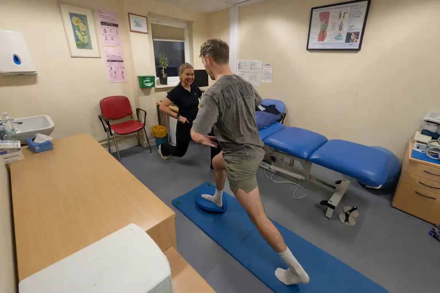 Physiotherapist guiding a patient through a single-leg balance and lunge exercise for lower limb rehabilitation at Phoenix Physio clinic